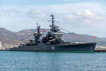 Novorossiysk, Russia - 18 August 2023. Cruiser Mikhail Kutuzov and dolphins, Black Sea, port,...