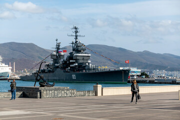 Novorossiysk, Russia - 18 August 2023. Cruiser Mikhail Kutuzov and dolphins, Black Sea, port,...