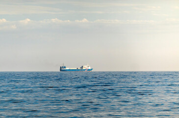 Sea freighter sailing in the middle of the ocean with big waves.