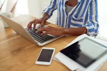 Woman, technology and hands at desk for blog, social media and research in apartment. African...