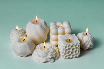 Soy wax handmade candles on teal background. Delicate scented candle made of natural materials. Interior decor