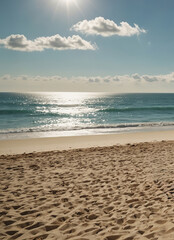 Sunny beach with sparkling ocean and footprints