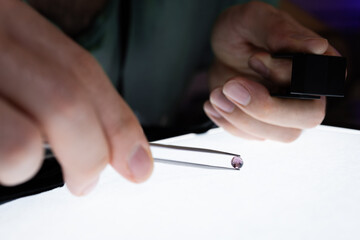 A gemmologiste studying an amethyst