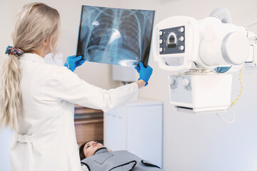 female doctor examines pictures of the lungs and ribs in the x-ray room	