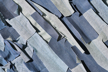A pile of shredded raw denim fabric in a denim factory. Industrial fabric and fashion manufacture....
