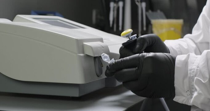Laboratory scientific research. Close-up scientist or chemist examines a sample using colorimeter. Lab research experiment