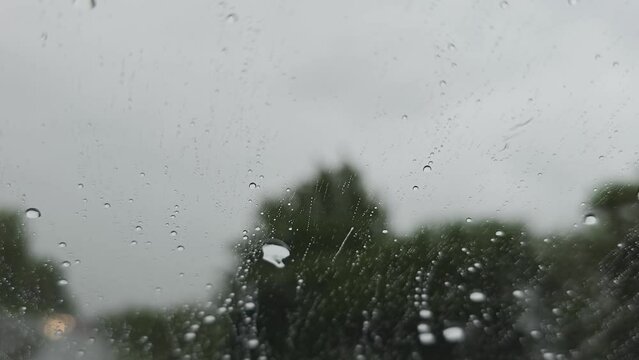 Fahrzeug f&auml;hrt bei Regen mit versiegelter Scheibe, die Regentropfen perlen ab fahrt auf der Landstra&szlig;e