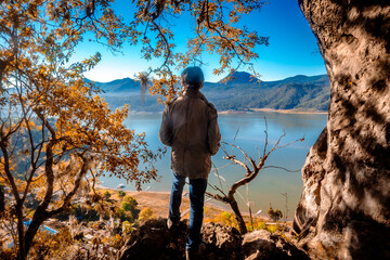 Man facing a cliff, with the lake in Bravo Valley, State of Mexico