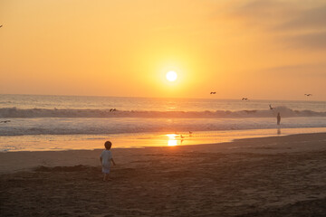 Fototapeta premium Little boy playing in sand at the beach during vacations in Peru
