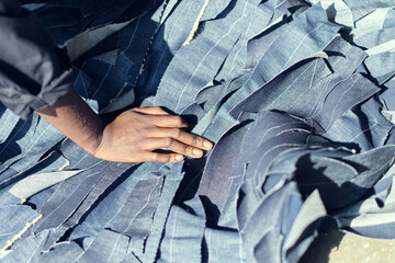A pile of shredded raw denim fabric in a denim factory. Industrial fabric and fashion manufacture. Stylish blue denim fabric for wholesale and jean recycling.