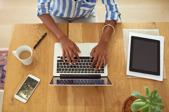 Hands, smartphone and laptop with person typing for remote job, online work and communication. Mobile, coffee and tablet in home office for copy editor, english teacher and virtual assistant