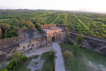 Fototapeta na wymiar Aerial view of ruins of Rohtas fort Pakistan, The main gate outpost and watch tower on green hill.