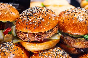 Tasty vegetarian fast or street food, homemade burgers made from orange lentils legumes with onion, green lettuce and tomatoes