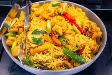 Local asian food, singapore noodle dish with vegetables, fried shrimps and chicken meat