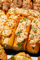 Fresh baked brioche buns filled with crab meat and shrimps ready to eat in food hall, London, Covent Garden market