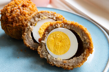 Traditional street food in UK, stuffed fried Scotch eggs with breadcrumbs close up