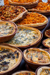 Tasty vegetarian streetfood for lunch in London, various quiche savoury tart swith spinach, tomatoes, mushrooms, cheddar cheese