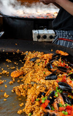 Street food in London, food court on Portobello road Saturday market, fresh prepared colorful paella with rice and sea food big pan, ready to eat