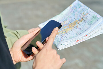 地図とスマートフォンを持つ男女の手元