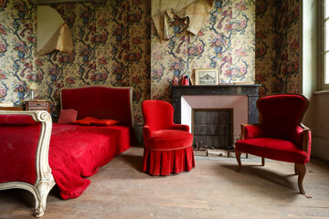 old abandoned bedroom with a bed, chairs and a chimney