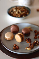 Cup of tea or coffee, cookies, macaroons, chocolate, various nuts and cocoa powder on white background. Selective focus.