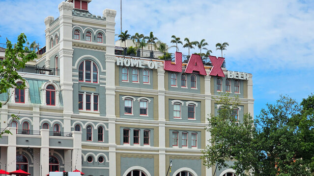 The Shops at Jax Brewery with lush green trees and plants, blue sky and clouds in New Orleans Louisiana USA