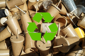 Green recycle symbol with disposable brown paper cups and plastic glasses used from coffee cafe,...