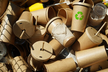 Recycle symbol on disposable brown paper cups and plastic glasses used from coffee cafe,...