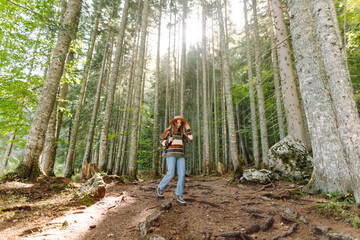 Woman tourist with backpack standing at footpath in woodland. Trips. Active lifestyle.
