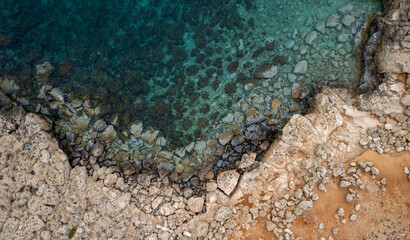 Drone aerial of rocky sea coastline transparent turquoise water. Seascape top view.