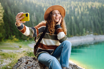 Woman uses a telephone for take pictures, make selfies and video calls friends and family on...