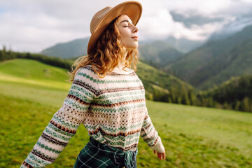 Portrait of a young cute attractive smiling girl traveler travelling in a mountain valley. Adventure, travel concept.