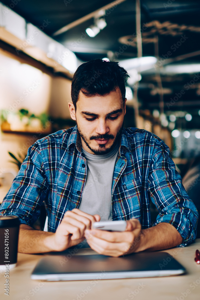 Aufkleber pensive hipster guy checking notification from social networks reading income message on cellular,yo