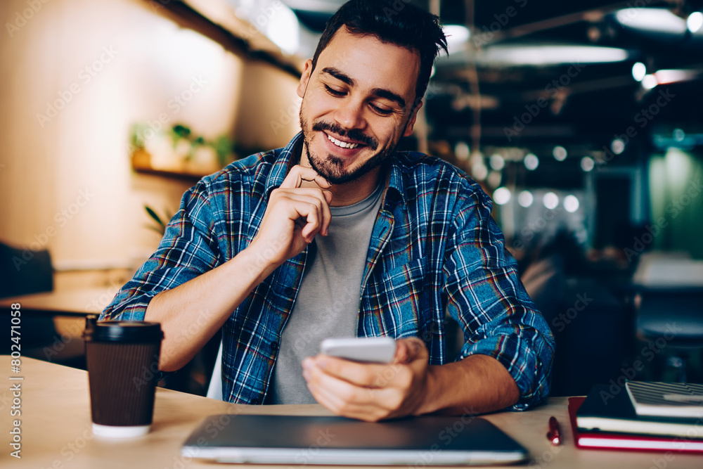 Aufkleber smiling hipster guy reading new message in social networks confirming new friend on smartphone, posi