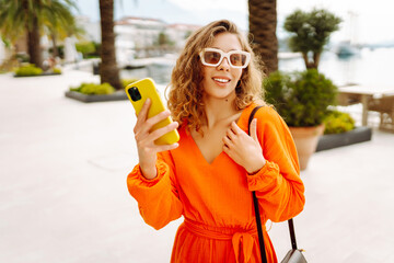 Young woman smiling confident using smartphone at street in the European city. Travel, fashion,...