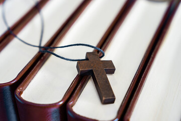 Necklace with wooden cross on books, Christian concept, religious symbol