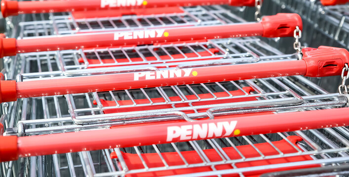 Viersen, Germany - May 1. 2024: Logo lettering of german discounter Penny on shopping carts handle in row