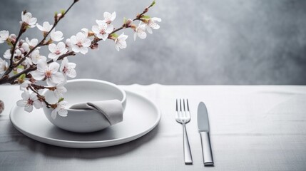 Spring table setting with cherry blossom twigs on light wooden background