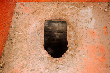 Photo of a hole in an old smelly dirty metal rusty rural toilet in Russia. Concept of poverty, poor.