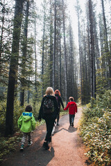 Women and children hiking along a trail in the woods