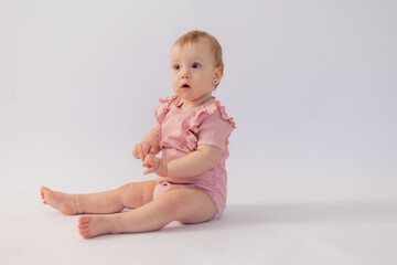 Cute baby girl in pink bodysuit on white background, space for text