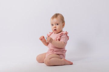 Cute baby girl in pink bodysuit on white background, space for text
