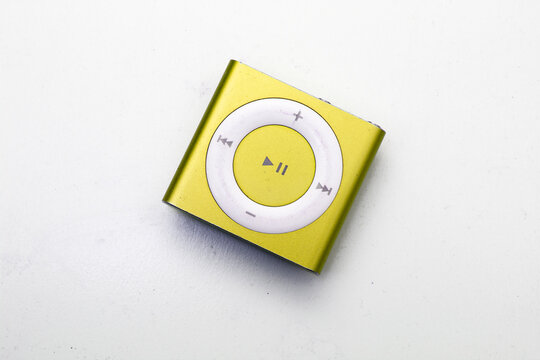 Saint-Petersburg, Russia - May 10, 2022: Golden yellow square music player iPod Shuffle isolated on white background. Concept of vintage, technique, technology, discontinuation, collecting, song, sing