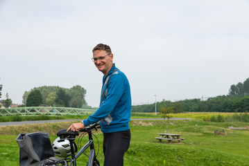 Forty year old man at the Senne valley standing with a bike, Eppegem, Belgium