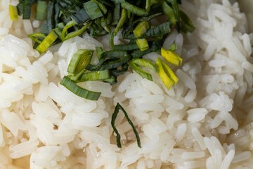 Boiled jasmine rice sprinkled with chopped raw leek - fish broth