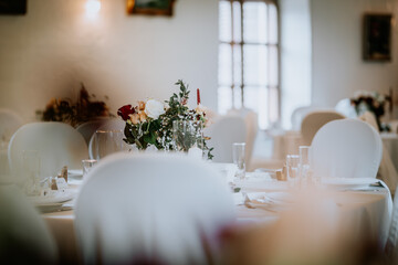 Valmiera, Latvia - August 19, 2023 - A softly focused wedding table setting with a lush floral...
