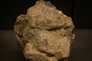 Macro close up of golden send shining stone. Black background Isolated gemstone, particle element...