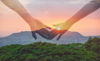 Man and woman's hands coming together in the sunset, love, relationships, togetherness concept