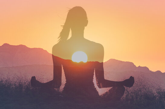 Woman in yoga pose, zen meditation at sunset.
