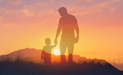 Father's and his son holding hands at sunset field. Dad leading son over summer nature outdoor....